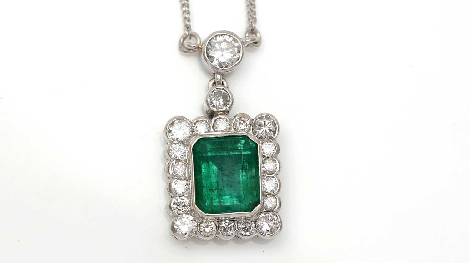 Lot 457 - An emerald and diamond cluster pendant