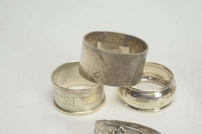 Lot 102 - A selection of silver napkin rings, and a silver mounted pot cover.