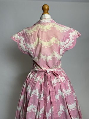Lot 829 - A late 1940s Horrockses printed cotton day dress | in a stylised scalloped lace pattern on pink