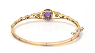 Lot 352 - An Edwardian amethyst and seed pearl bangle