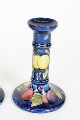 Lot 689 - A matched pair of Moorcroft Wisteria pattern candlesticks