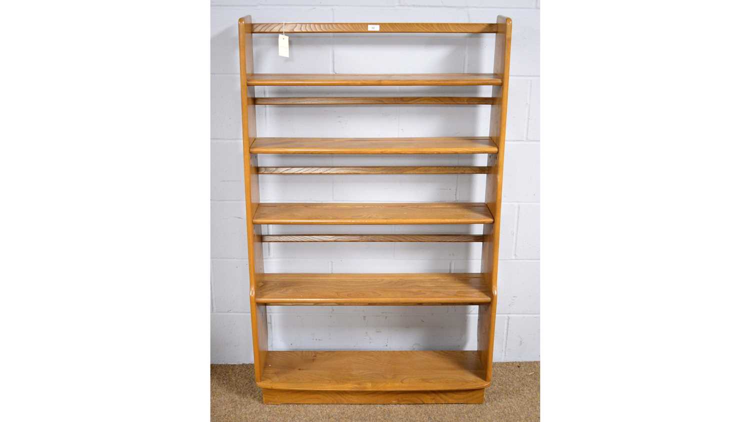 Lot 32 Ercol a light elm graduated open bookcase.
