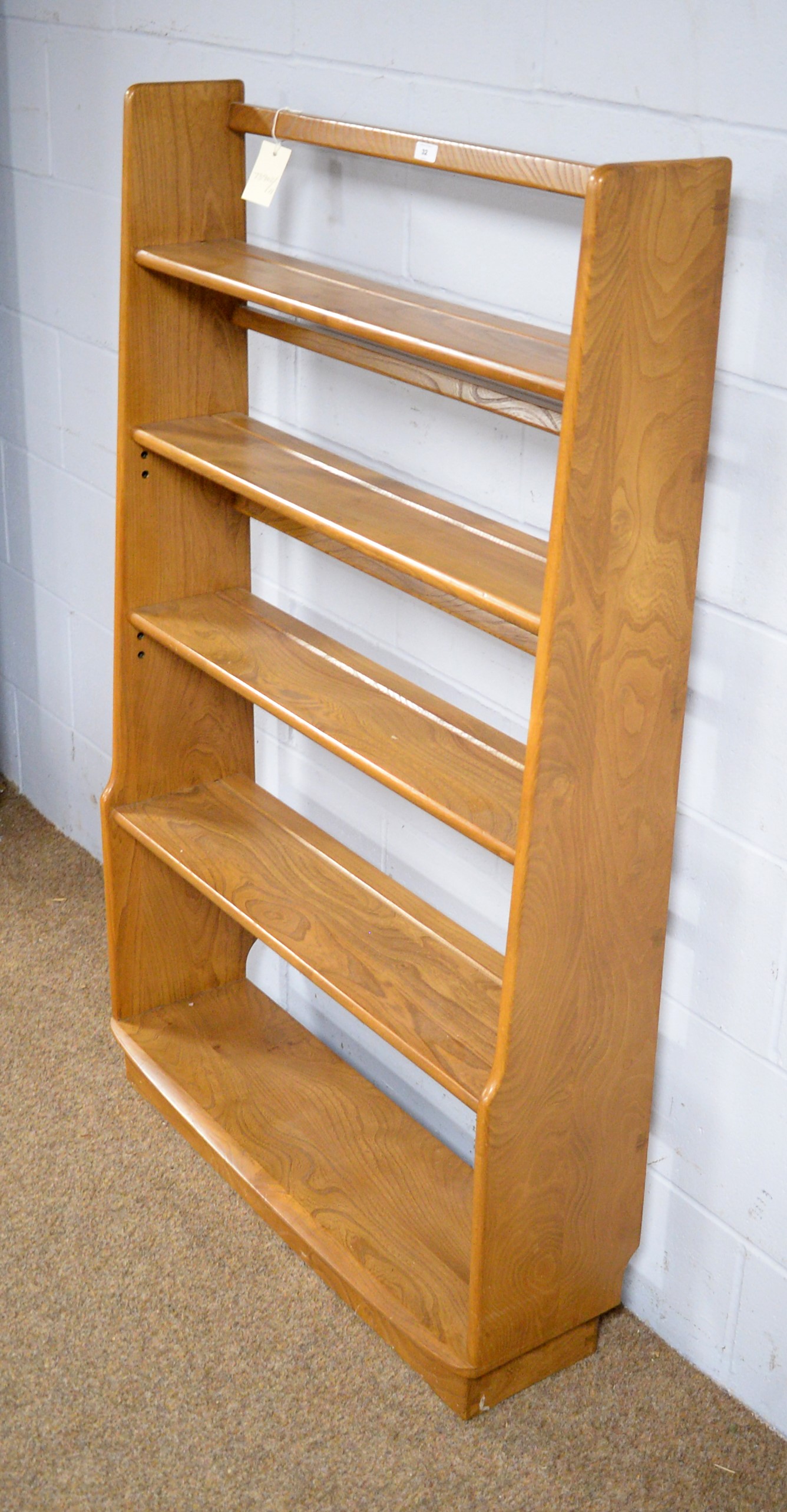 Lot 32 Ercol a light elm graduated open bookcase.