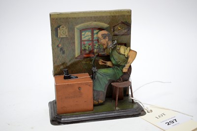 Lot 297 - An early 20th Century German tinplate cobbler toy; together with a Magic £ note machine, in box.