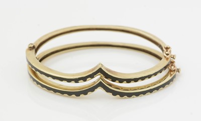 Lot 498 - A pair of 14ct yellow gold and black enamel bangles