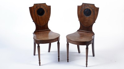 Lot 1163 - A pair of George III mahogany hall chairs.