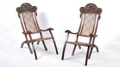 Lot 1143 - A pair of early 20th Century Indo Portuguese rosewood folding steamer chairs.