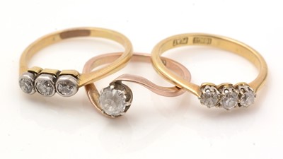 Lot 104 - Two three stone diamond rings and a white stone ring
