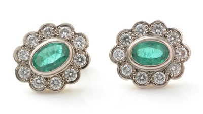 Lot 503 - A pair of emerald and diamond cluster earrings