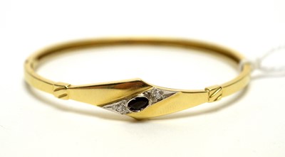 Lot 998 - A 14K gold, sapphire, and diamond hinged-bangle