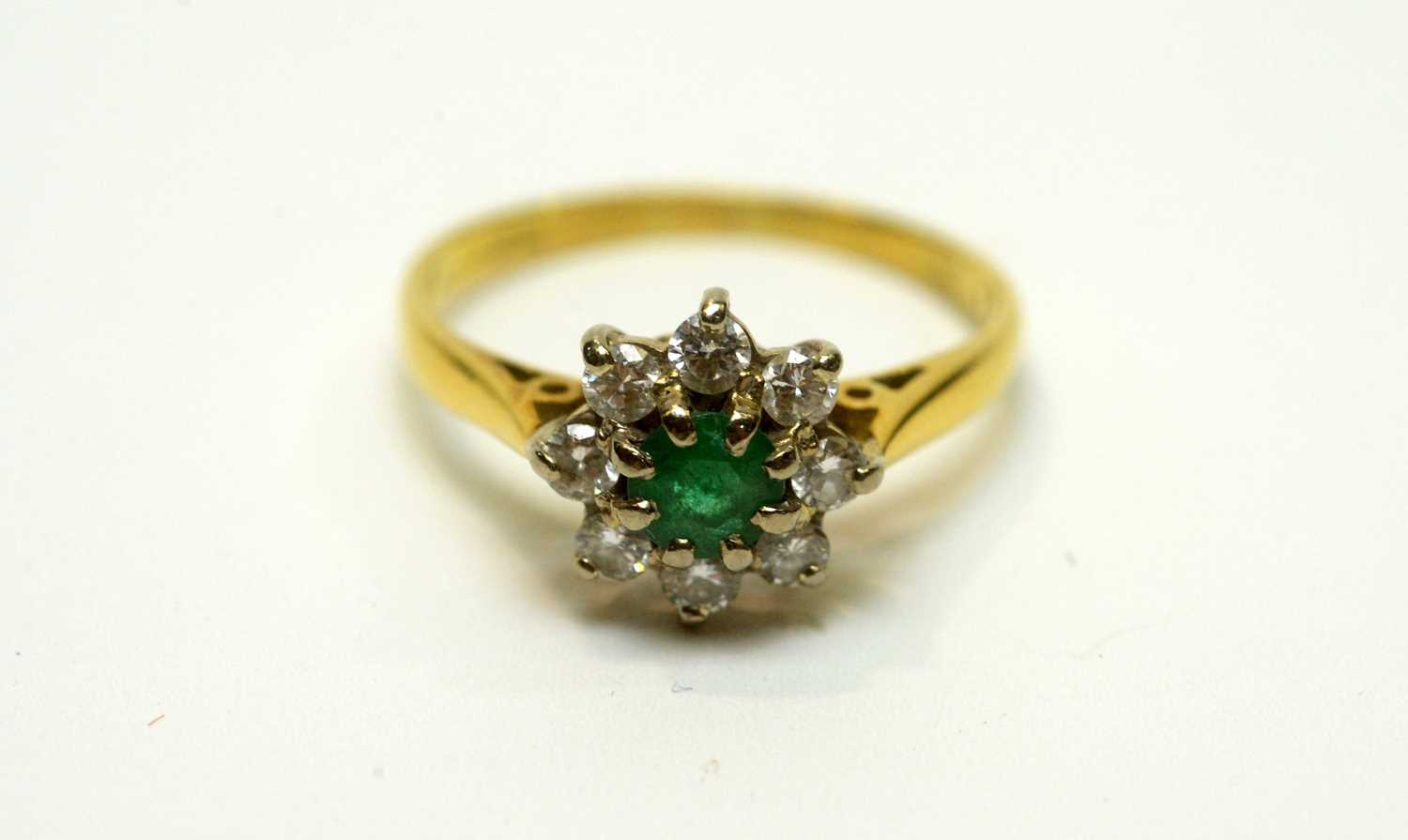 Lot 180 - An emerald and diamond cluster ring