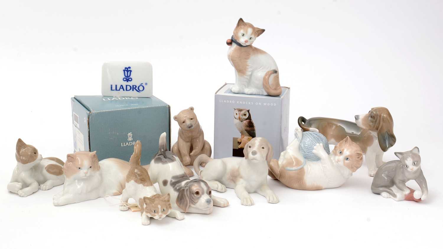 Lot 708 - Four Lladro figures; five Nao figures; and a Lladro display sign.