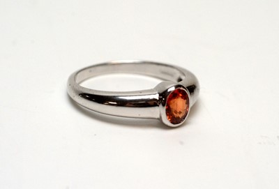 Lot 216 - An orange sapphire ring