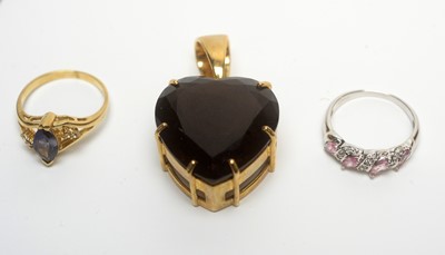 Lot 224 - A smokey quartz heart-shaped pendant, and four gem set rings