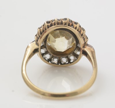Lot 664 - A yellow sapphire and diamond cluster ring