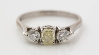 Lot 411 - Three stone yellow and white diamond ring