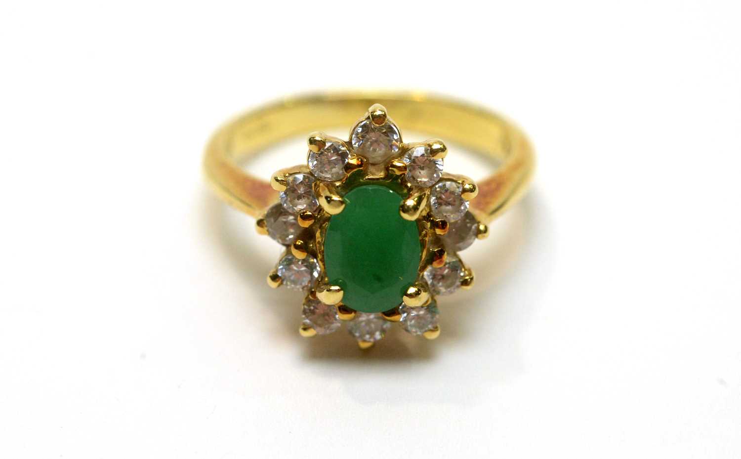 Lot 185 - An emerald and white stone cluster ring