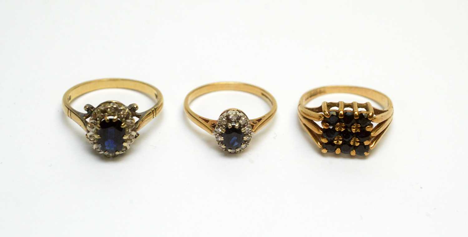 Lot 104 - Two sapphire and diamond cluster rings, and a nine-stone sapphire ring