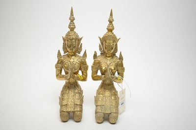 Lot 440 - A pair of Eastern seated brass Buddha figures, comprising a male and female.