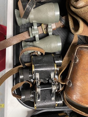 Lot 451 - Two pairs of binoculars; together two leather bound canvas bags.