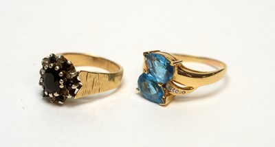 Lot 139 - A topaz and diamond and sapphire and diamond ring