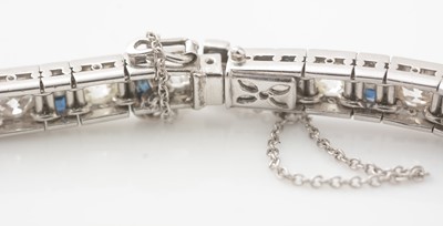 Lot 557 - A fine graduated diamond and sapphire bracelet