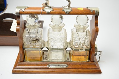 Lot 306 - A Victorian mahogany three bottle tantalus with silver plated mounts