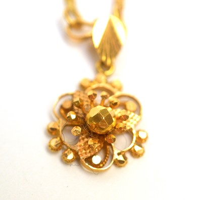 Lot 165 - An 18ct yellow gold floral pendant on fancy link chain