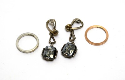 Lot 1146 - An 18ct white gold band; 9ct rose gold ring; and a pair of earrings