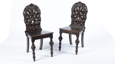 Lot 1321 - A pair of 19th Century carved oak hall chairs