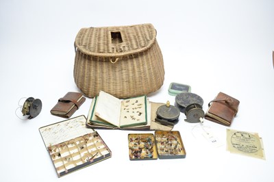 Lot 334 - A collection of vintage fishing reels; fishing flies, contained in a wicker basket
