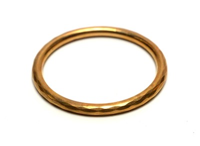 Lot 1011 - A 9ct gold faceted bangle