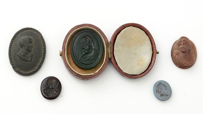 Lot 1083 - A green glass intaglio seal, a carved lava stone classical female bust panel and others