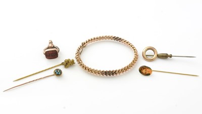 Lot 1087 - A 9ct yellow gold beadwork bangle, four tie pins and a fob seal