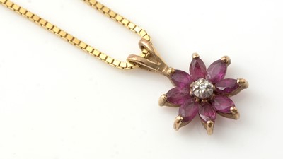 Lot 198 - A diamond and ruby flowerhead pattern cluster pendant