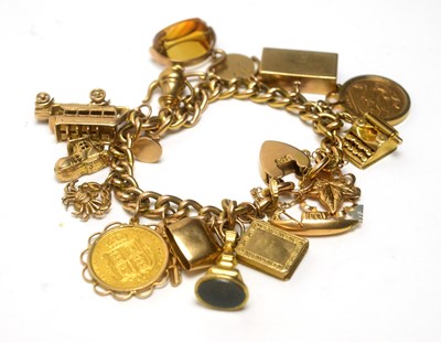 Lot 83 - A 15ct yellow charm bracelet with two half sovereign charms and others
