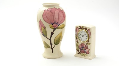 Lot 130 - Moorcroft magnolia pattern clock and a vase.