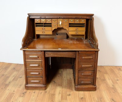 Lot 60 - An early 20th Century roll-top pedestal desk