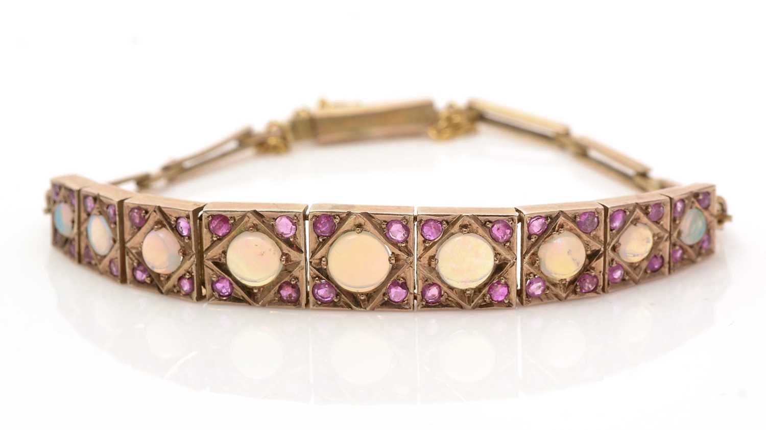 Lot 1074 - An opal and ruby bracelet