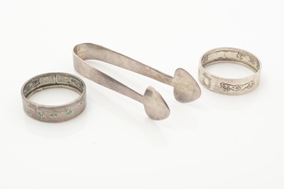 Lot 8 - A pair of Edwardian silver “CYMRIC” sugar tongs; and two napkin rings