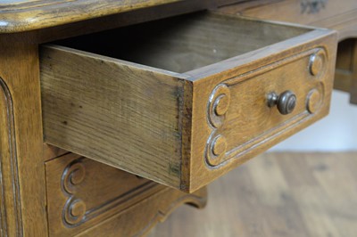 Lot 6 - A French-style oak serpentine fronted writing desk