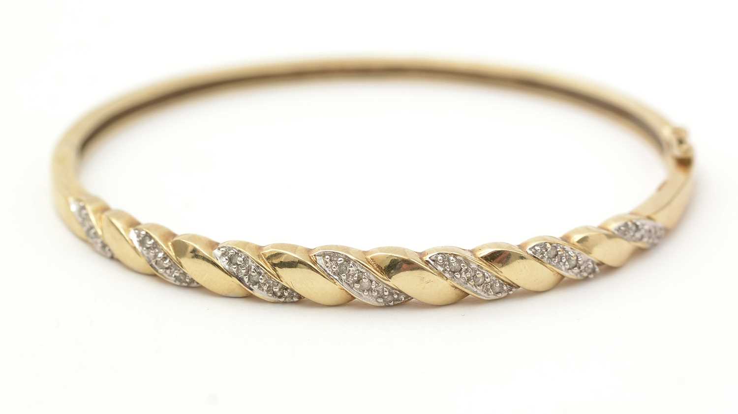 Lot 137 - A diamond and 9ct yellow gold bangle