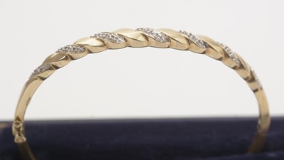 Lot 137 - A diamond and 9ct yellow gold bangle