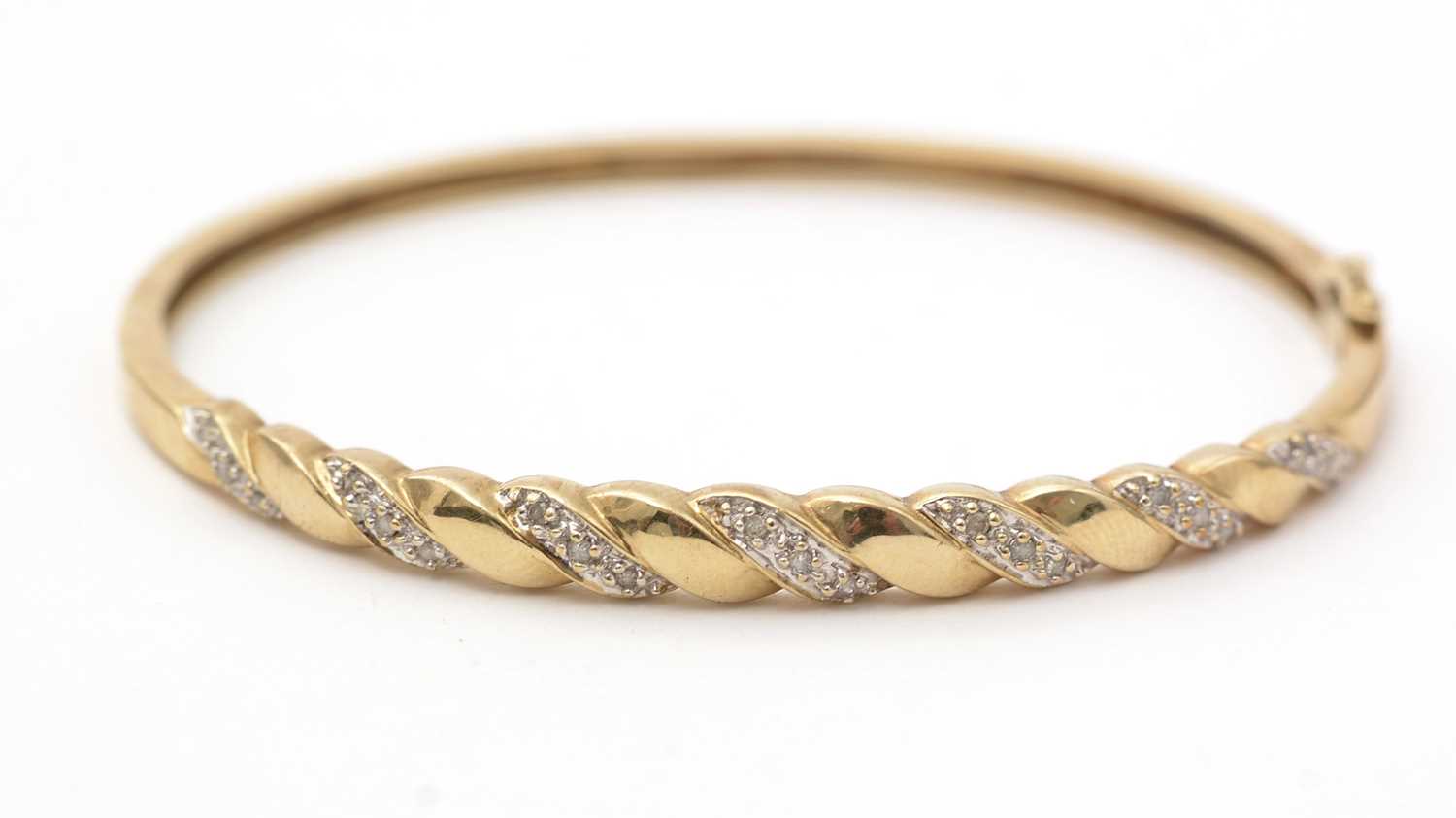 Lot 141 - A diamond and 9ct yellow gold bangle