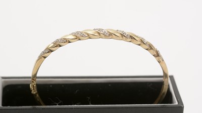 Lot 141 - A diamond and 9ct yellow gold bangle