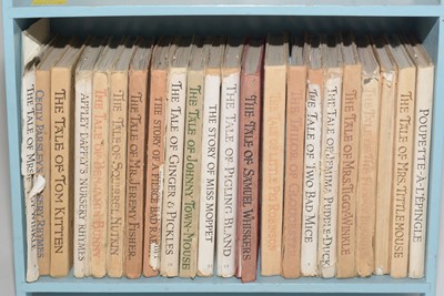 Lot 820 - A collection of Beatrix Potter books on a small bookshelf.
