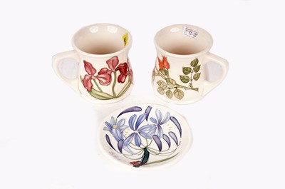 Lot 4 - Two Moorcroft ceramic mugs, and a Moorcroft pin dish