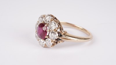 Lot 1153 - A ruby and diamond cluster ring