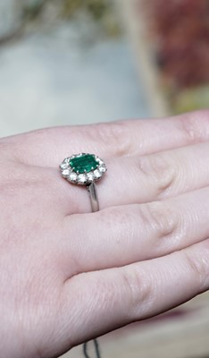 Lot 1314 - An emerald and diamond cluster ring