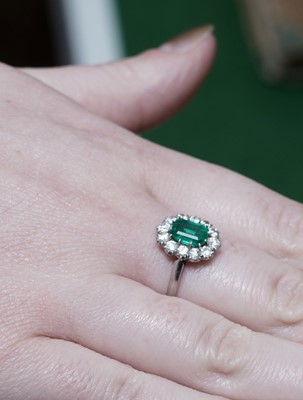 Lot 1314 - An emerald and diamond cluster ring